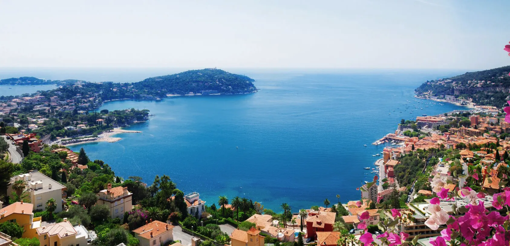Jardin méditerranéen entretenu sur la Côte d’Azur avec allée, massifs fleuris et fontaine.